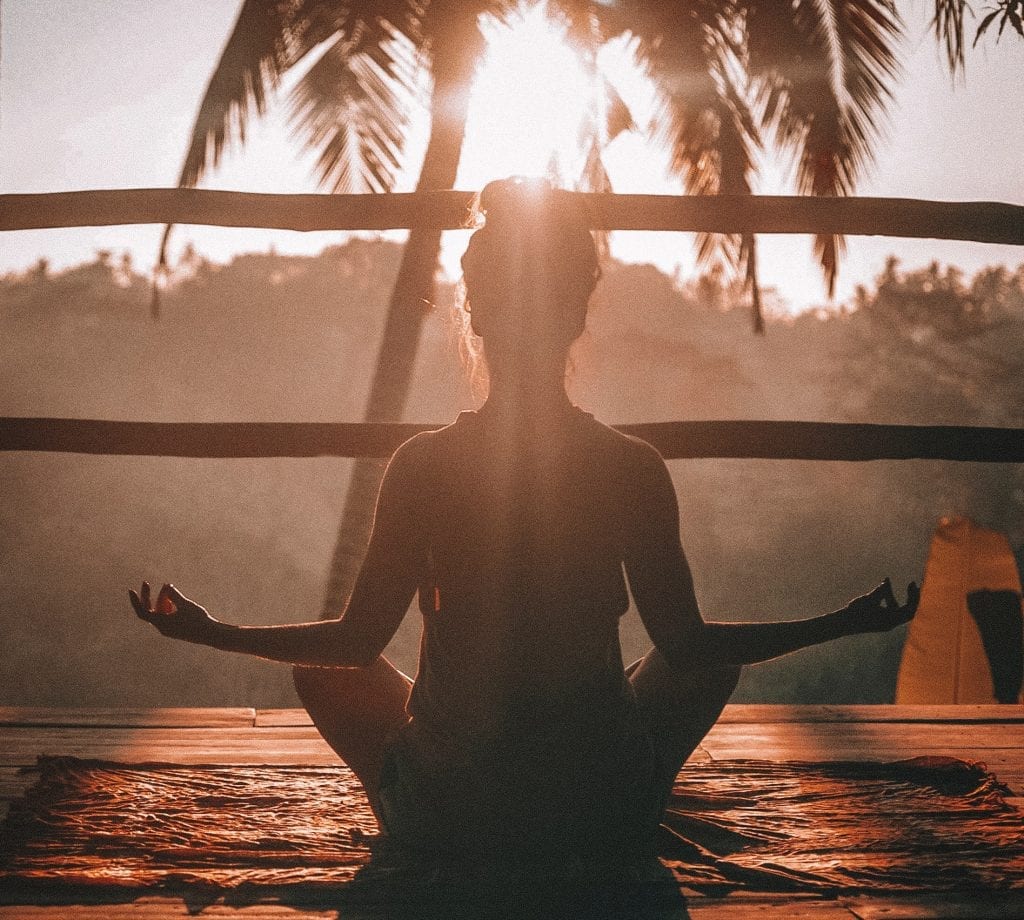 woman meditating on sunset