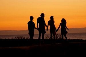 family holding hands during sunset